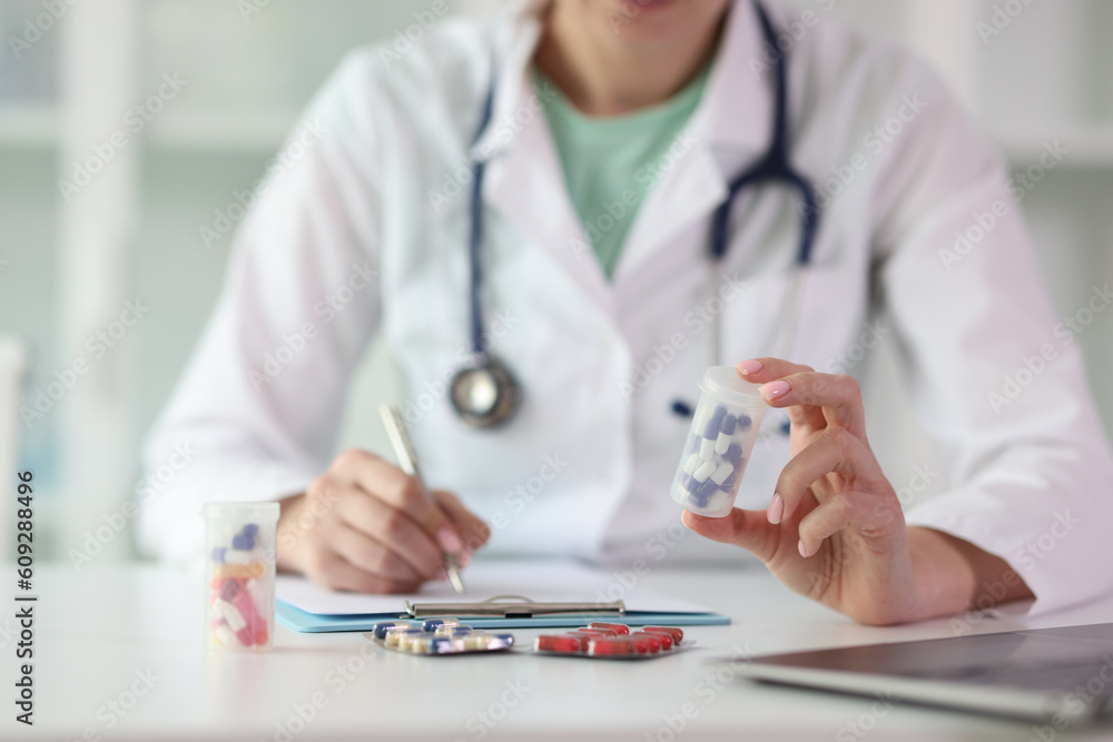 Doctor prescribes medicine sitting at table in clinic Doctor prescribes medicine sitting at table in clinic