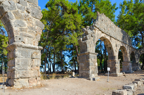 Ruins of aqueduct in ancient city of Phaselis near Camyuva, Turkey photo