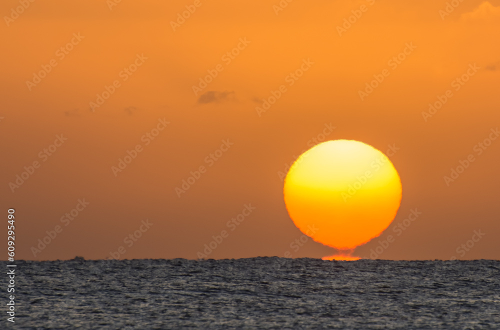 magic sunrise with a burning and torn orange sun at the horizon from the red sea in egypt large