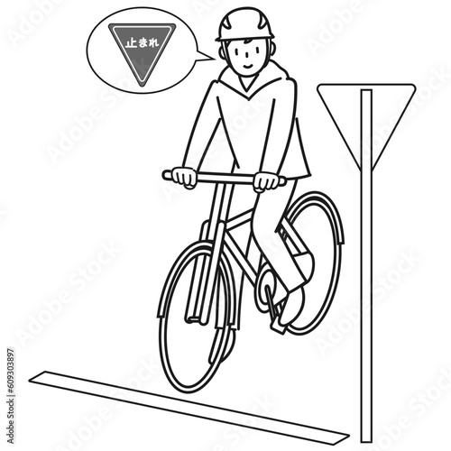 標識を見て一時停止する自転車に乗った若い男性