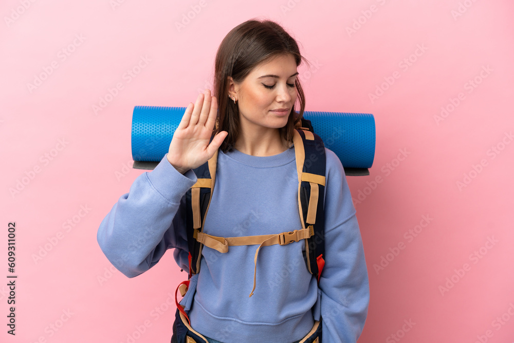 Young mountaineer woman with a big backpack isolated on pink background making stop gesture and disappointed Young mountaineer woman with a big backpack isolated on pink background making stop gesture and disappointed