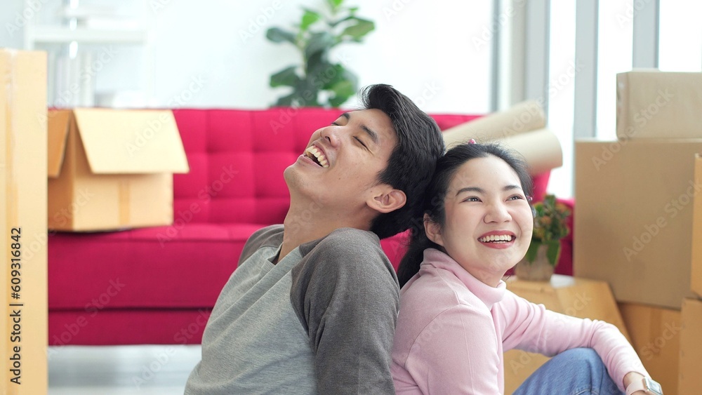 Happy young asian couple sitting on floor in living room at new house on moving day. Happy couple, Moving house Happy young asian couple sitting on floor in living room at new house on moving day. Happy couple, Moving house