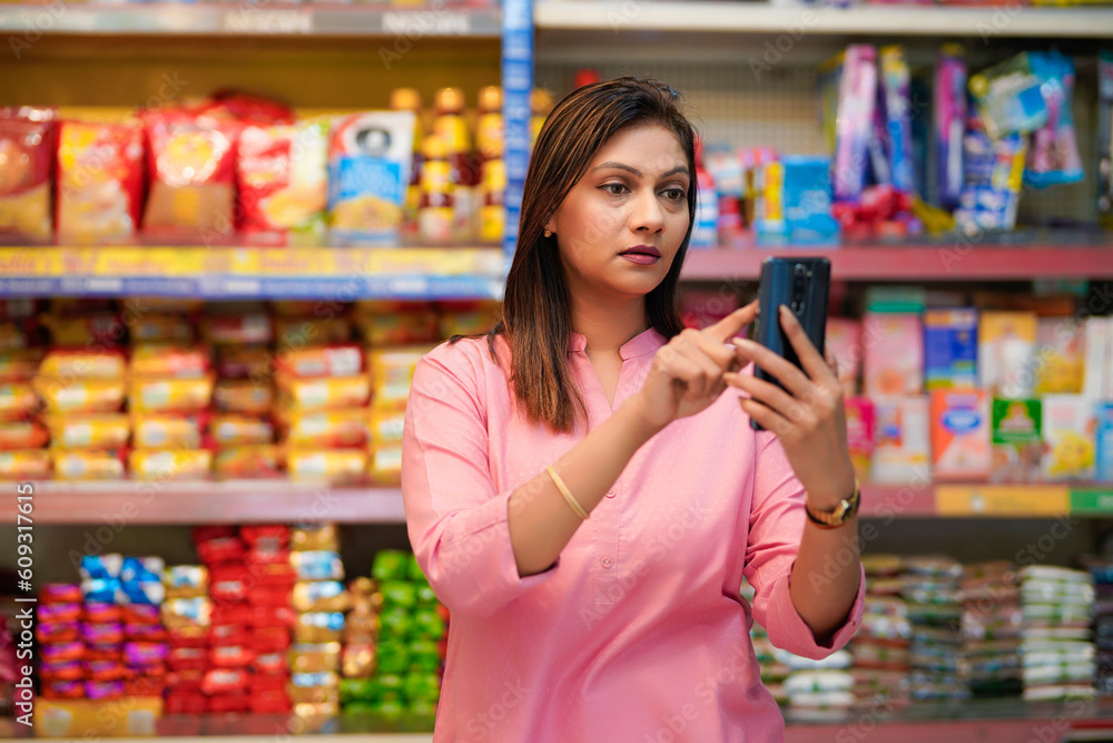 Indian woman using smartphone at super market