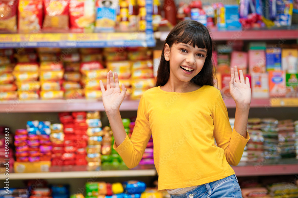 Indian girl giving expression with hand at grocery shop.