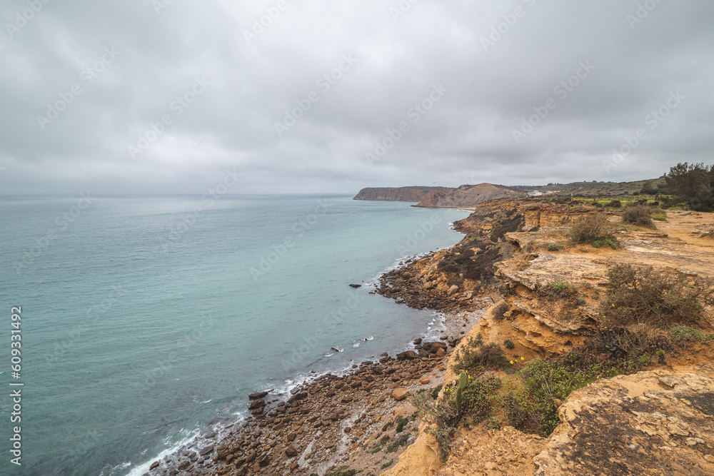 Mountainous coastline of Portugal's southern peninsula in the famous tourist region of the Algarve. The rocky cliffs around the town of Luz. Discovering the Fisherman trail, Rota Vicentina Mountainous coastline of Portugal's southern peninsula in the famous tourist region of the Algarve. The rocky cliffs around the town of Luz. Discovering the Fisherman trail, Rota Vicentina