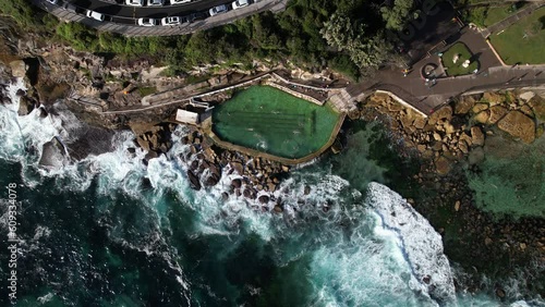 People swimming in Bronte Baths ocean pool with waves crashing.