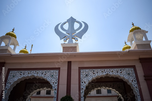 Khanda Sikh holy religious symbol at gurudwara entrance with bright blue sky image is taken at Sis Ganj Sahib Gurudwara in Chandni Chowk, opposite Red Fort in Old Delhi India photo