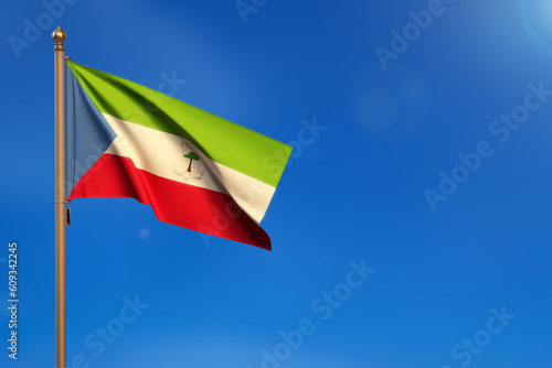 Ecuatorial Guinea. Flag blown by the wind with blue sky in the background.