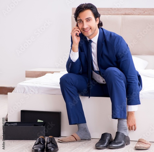 Young handsome businessman choosing shoes at home