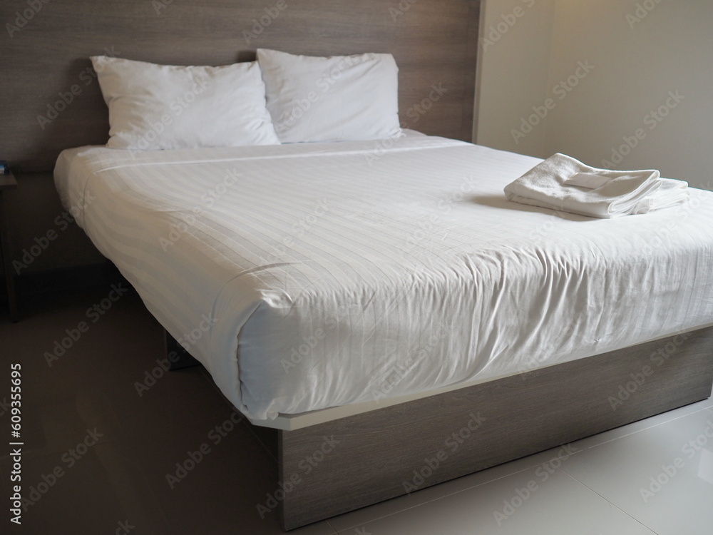 Foto de White sheets and two white pillows lean against the head of the bed. The calm atmosphere