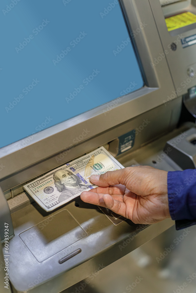 Detail of a man's hand taking dollar bills out of an ATM. Detail of a man's hand taking dollar bills out of an ATM.