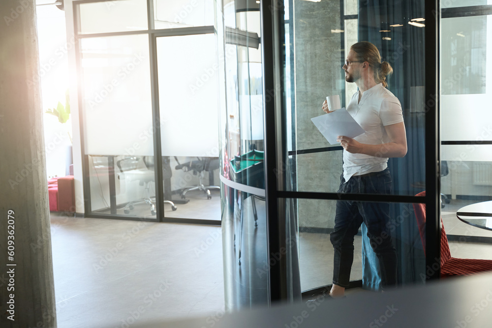 Serious male standing at exit from room Serious male standing at exit from room