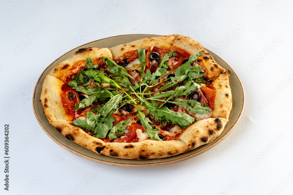 Home made pizza topped with black forest ham, tomatoes, spices, black olives, on white background