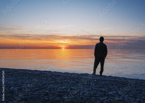 A man standing alone on the beach