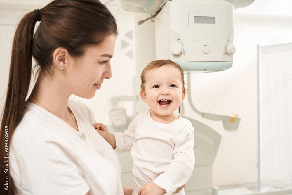 Fototapeta premium Young mom and joyful infant before radiography procedure
