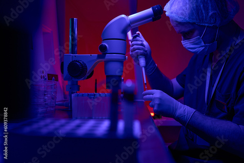 Science laboratory engineer adding cells to test tubes photo