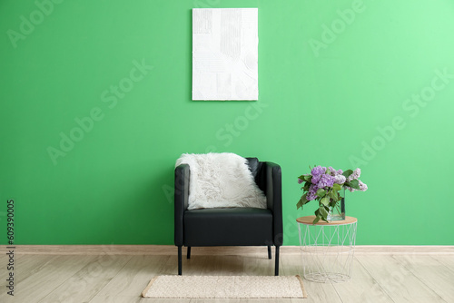 Interior of room with armchair  table and bouquet of lilac flowers