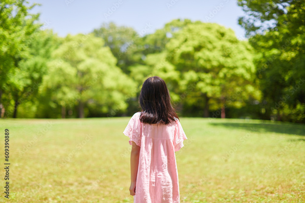 夏の公園で散歩している可愛い小学生の女の子 夏の公園で散歩している可愛い小学生の女の子