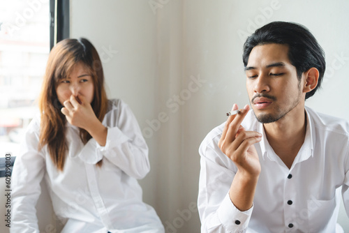 passive smoking effect, person cover his nose and avoid smoker near him photo