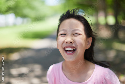 夏の公園で遊んでいる可愛い女の子の笑顔
