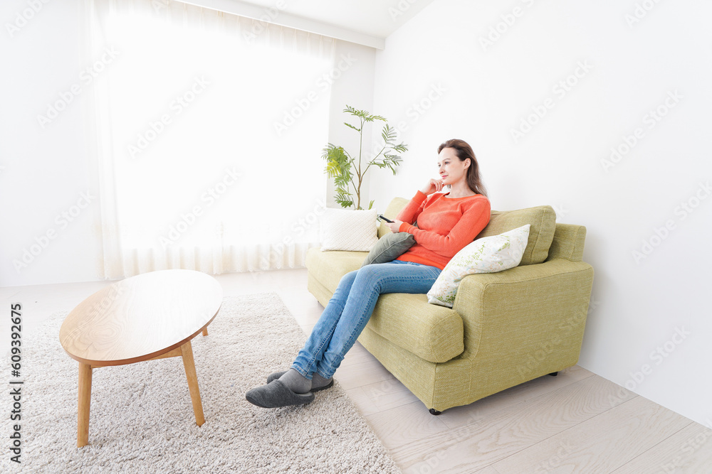 家でテレビを見る女性
