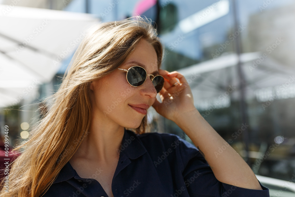 Portrait of beautiful woman smiling and looking away at park during sunny day. Outdoor portrait of a smiling girl. Happy cheerful girl laughing at city street in sunglasses Portrait of beautiful woman smiling and looking away at park during sunny day. Outdoor portrait of a smiling girl. Happy cheerful girl laughing at city street in sunglasses