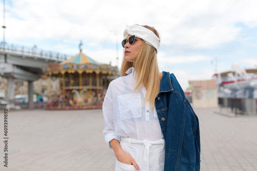Outdoor portrait of cheerful caucasian woman in glasses looking aside on city background. Photo of fashionable girl with beautiful smile and enjoying time in the city