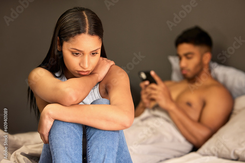 Sad woman, couple fight and man typing with digital affair, relationship problem and depressed in bed. Breakup, divorce talk and cheating with female person feeling stress and guilty in home bedroom photo