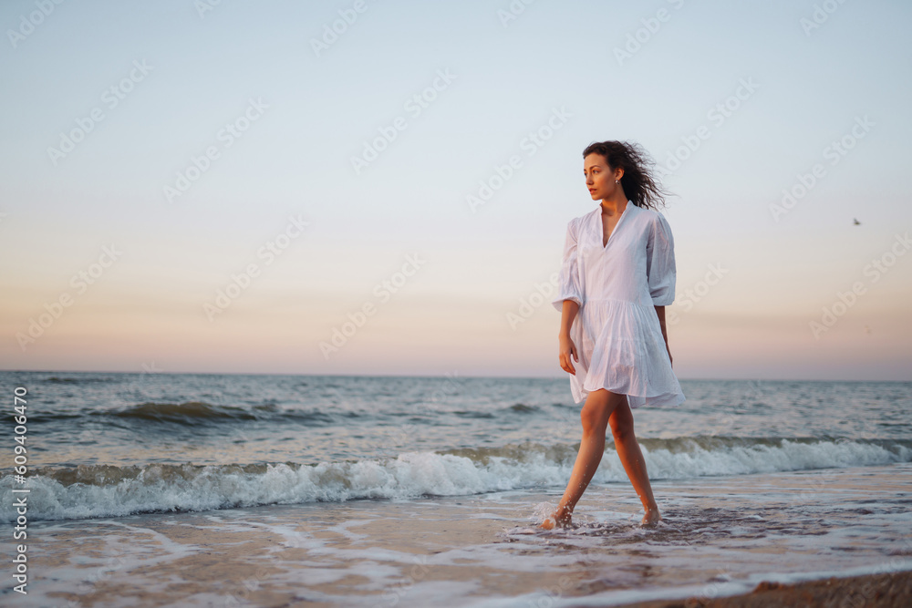Beautiful woman walking at a beach at sunset. Summer time. Travel, weekend, relax and lifestyle concept. Beautiful woman walking at a beach at sunset. Summer time. Travel, weekend, relax and lifestyle concept.