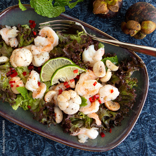 plate with salad with shrimps and mangosteen on the table
