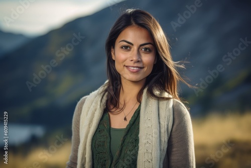 Outdoor portrait of a beautiful young woman smiling in the mountains.