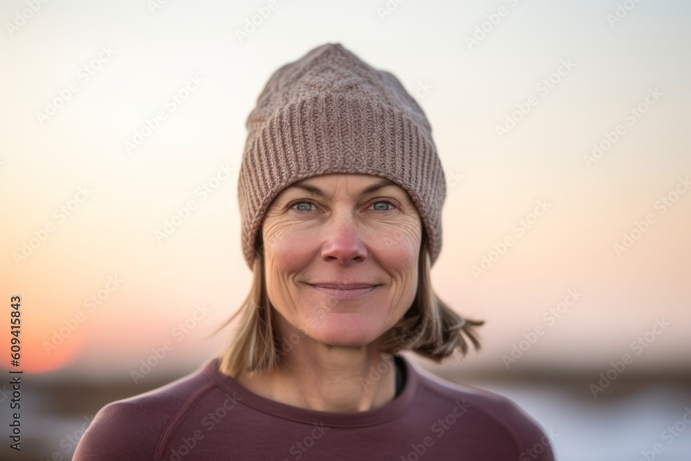 Portrait of smiling senior woman wearing knit hat on beach during sunset Portrait of smiling senior woman wearing knit hat on beach during sunset