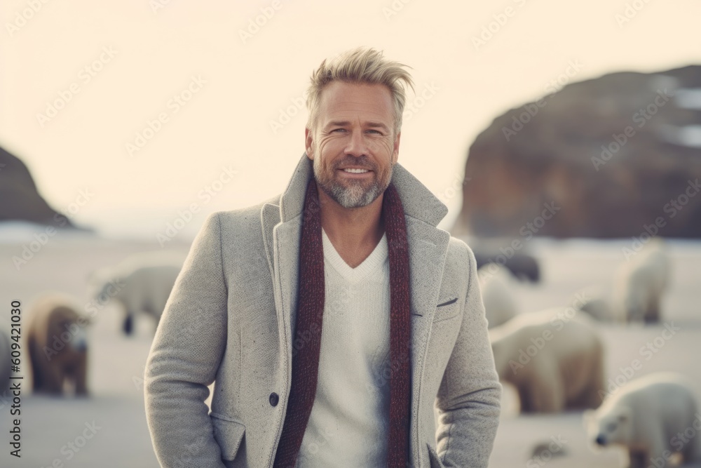 Portrait of a handsome middle-aged man in a coat on the background of a herd of polar bears. Portrait of a handsome middle-aged man in a coat on the background of a herd of polar bears.