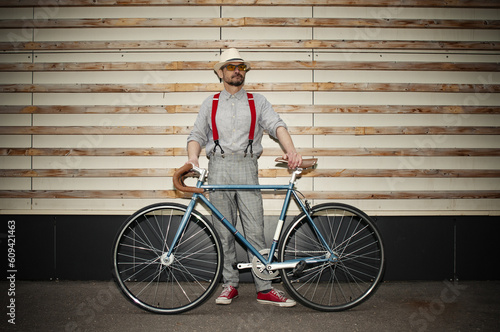 Fototapeta Naklejka Na Ścianę i Meble -  Adult hipster man with retro fixed gear bicycle on dark wall background
