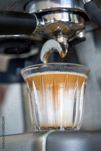 A barista is making a latte with an espresso machine