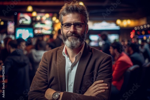 Portrait of handsome bearded businessman with eyeglasses standing in airport