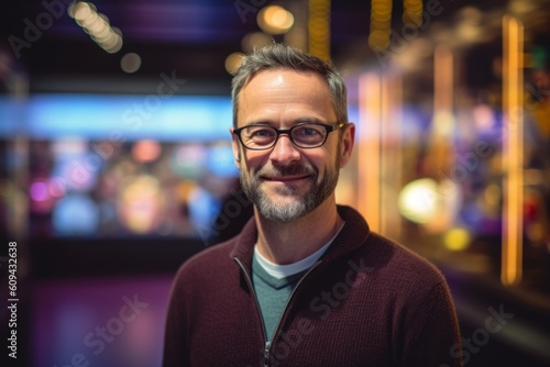 Portrait of smiling man with eyeglasses against blurry lights in nightclub