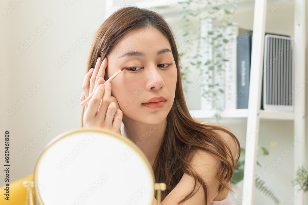 Happy beauty, skincare concept, smile beautiful healthy asian young woman, girl makeup brush apply nude eye shadow, looking into mirror in morning routine at home. make up natural fashion style.