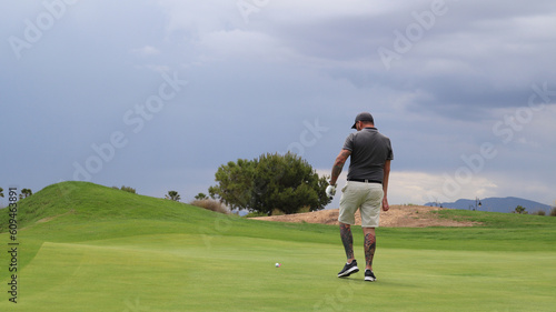 Professional one arm golfer hitting golf ball on the golf course. Concept of willpower of people with disabilities in sport