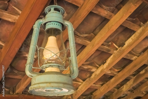 Classic shaped Electric paraffin pressure lamps or kerosene lamp pressure lantern. Old traditional storm lamps attached on javanese joglo limasan house wooden ceilings. Copy text empty blank space. photo