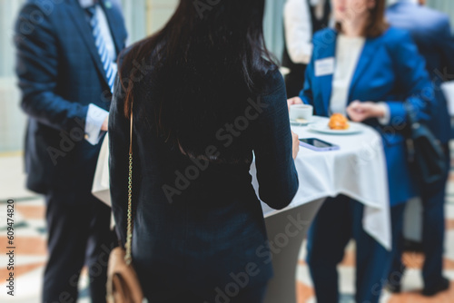 Group of women in business suits talking and discussing during coffee break at conference, female politicians and entrepreneurs networking and negotiate, businesswomen dialog conversation on forum