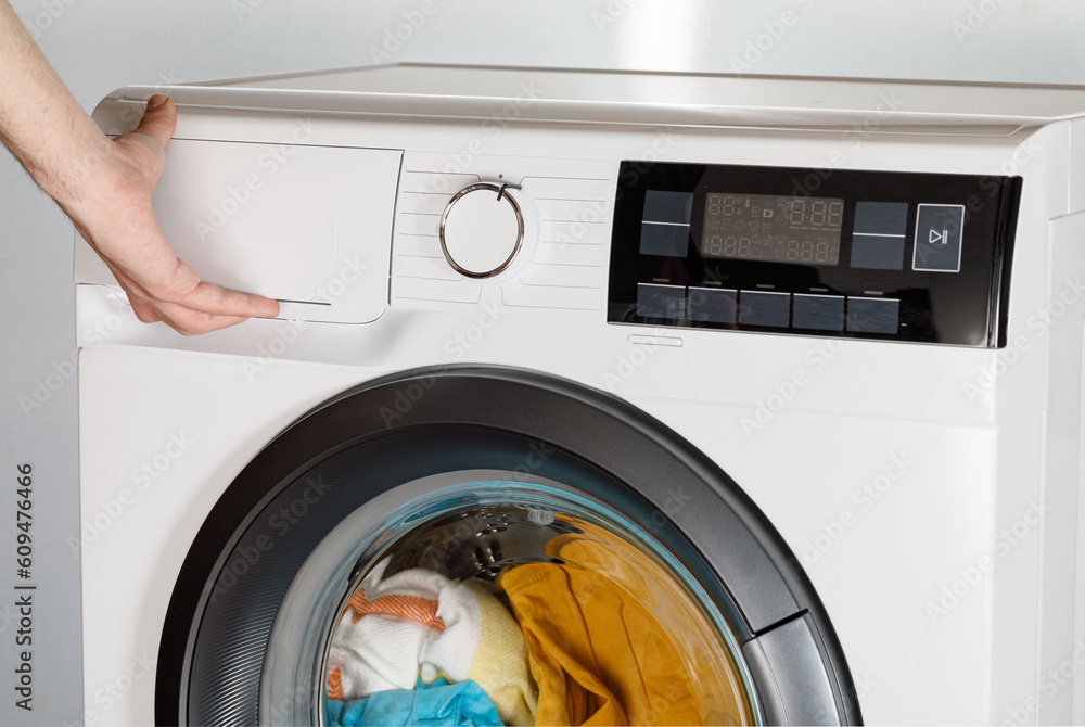 The hand select settings for laundry on modern digital display. Close-up view of automatic washing machine with touch screen on control panel. Press start or pause The hand select settings for laundry on modern digital display. Close-up view of automatic washing machine with touch screen on control panel. Press start or pause