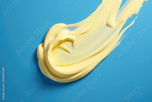 Top view of a smear of pastel yellow thick cream isolated on a flat blue background surface with copy space. Cosmetic cream, white paint. Generative AI professional photo imitation.