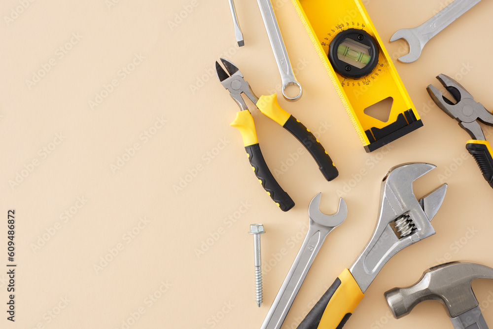 Traditional tools for technical works concept. Top view flat lay of pliers, wrenches, hammer, spirit level, on pastel beige background with empty space for text or commercial message