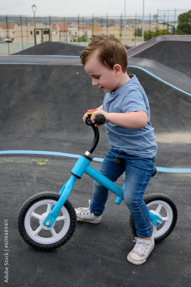 A young child rides the new South Glenmore Park BMX pump track on his bike on a summer evening in Calgary Alberta Canada. A young child rides the new South Glenmore Park BMX pump track on his bike on a summer evening in Calgary Alberta Canada.