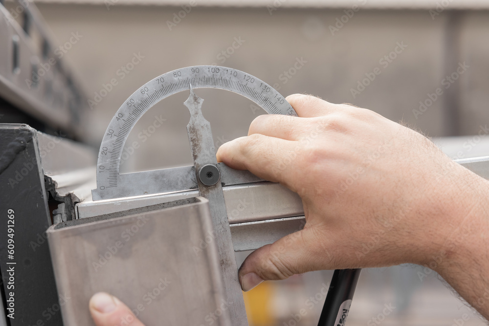 Measuring angle on aluminium profiles with angle meter. It is showing a little less than 90 degrees.