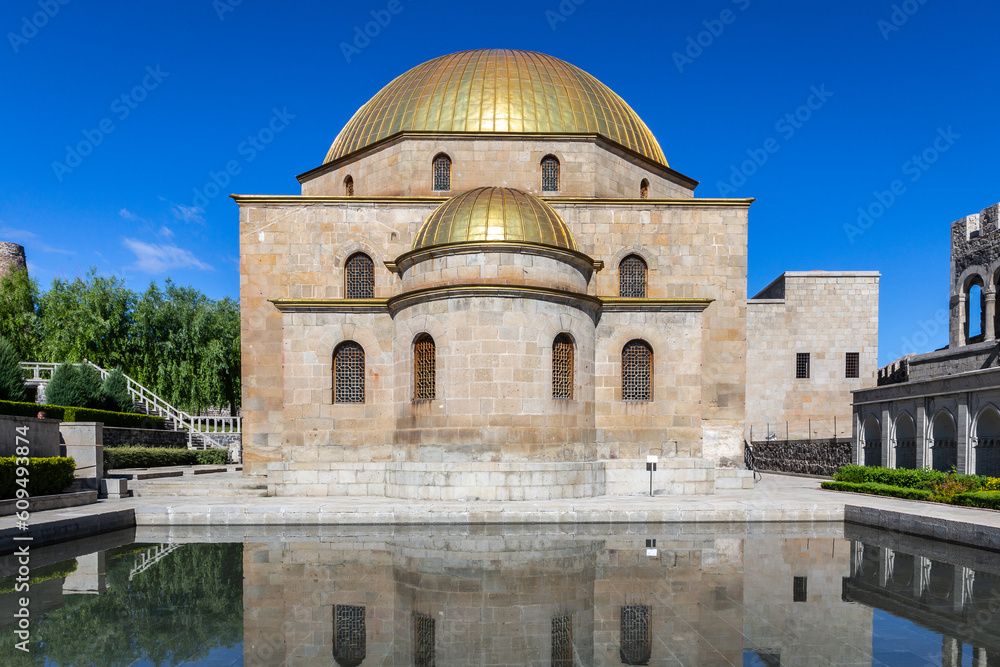 Akhmediye Mosque building with golden dome in Akhaltsikhe (Rabati) Castle courtyard with its reflection in a pond, symmetrical view.