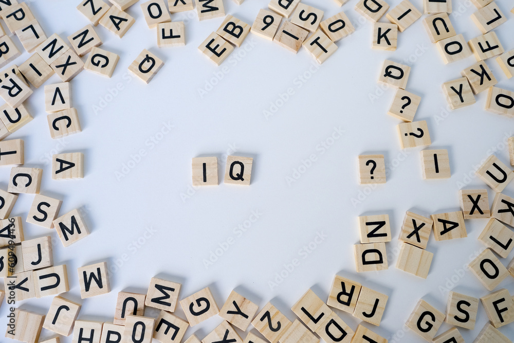 Obraz premium word IQ, wooden letters on wooden table, intelligence quotient on wooden background, quantitative indicator expressing success, concept of concept of level of mind, intellectual achievements