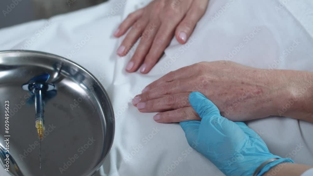 Cosmetology treatment - cosmetologist wiping the hands skin of her female client Cosmetology treatment - cosmetologist wiping the hands skin of her female client