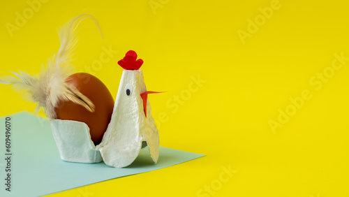 handmade rooster on yellow background. a stand for an egg in the form of a rooster.